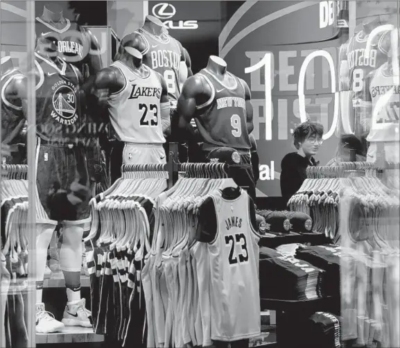  ?? JEENAH MOON/GETTY-AFP ?? Apparel is displayed at the NBA Store in New York City on Thursday — the day after the league suspended its season following Gobert’s positive test for the Coronaviru­s.