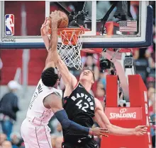  ?? NICK WASS THE ASSOCIATED PRESS ?? Wizards guard John Wall, left, beats Raptors defender Jakob Poeltl for the score as Washington tied the first-round NBA series at 2-2.