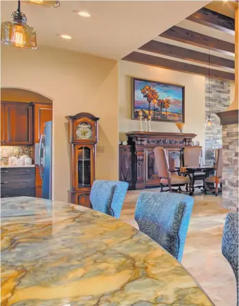  ??  ?? Above: The kitchen bar counter is in the foreground and the sub-kitchen can be seen in the background inside the arched doorway. Left: The main kitchen is in the foreground, while the sub-kitchen is in a walkway behind the counter and cabinet space.