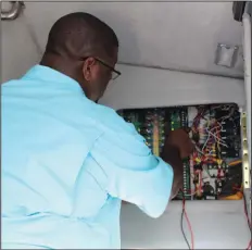  ?? Brittany Williams/News-Times ?? Fuses: Davis checks the fuses in the party bus with a 'top of the line' continuity and voltage tester.