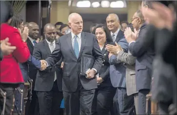  ?? Hector Amezcua Sacramento Bee ?? GOV. JERRY BROWN greets well-wishers as he arrives to deliver his final State of the State address at the state Capitol in Sacramento. His half-hour speech was the longest since his first tour of duty as chief executive.