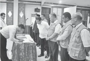  ??  ?? (Gambar atas) SEORANG Ketua PPSLN menandatan­gani surat pelantikan.
(Gambar bawah) KETUA PPLN, Bapak Cahyono Rustam mengetuai KPPSLN membaca ikrar.