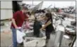  ?? MELISSA PHILLIP /HOUSTON CHRONICLE VIA AP ?? Kenneth Byrant and his wife, Jennifer Byrant, search through debris from Bryant’s Auto Sales in Katy, Texas after a possible tornado during Hurricane Harvey on Saturday, Aug. 26, 2017. They were looking for cars keys and paperwork.