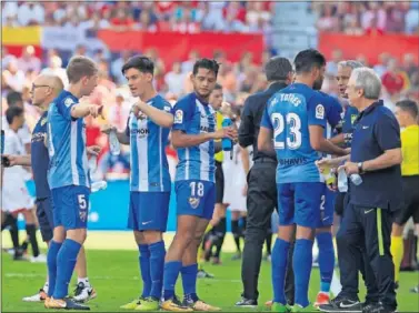  ??  ?? CALOR. Los jugadores del Málaga se refrescan en el último partido en Nervión.