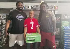  ?? SAUNDRA WATTS ?? NFL players Keith Marshall, left, and Rob Kelley say they were happy to see Jaden Watts, 10, wearing a Colin Kaepernick jersey.