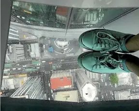  ?? BESS MANSON/STUFF ?? Do look down. Bess Manson takes a look through the glass floor in Auckland’s Sky Tower.