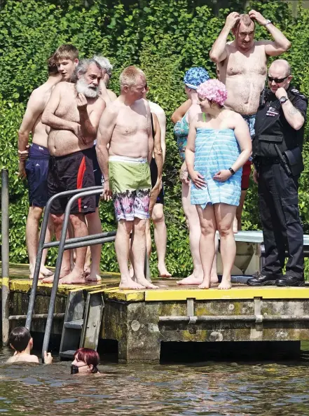  ??  ?? Making waves: Women protesters who infiltrate­d a male-only pool on Hampstead Heath this week — and a police officer called to evict them