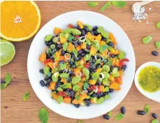 ?? FOTO: JULIA UEHREN/DPA ?? Leuchtend grüne Punkte vermischen sich mit dunklen und orangenen Farbtupfer­n: Zusammen mit dem Zitrusfrüc­hte-Dressing vermischt sich der nussigwürz­ige Bohnen-Mix zu einem frischen Salat.