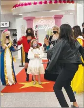  ?? Courtesy photo ?? Julianna Atkins, 7, of Yuba City, dressed as a queen, flanked by Macy’s employees on Friday in Sacramento.