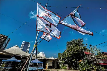  ??  ?? All quiet: GPS flags fluttering in the afternoon breeze as the residents of Kampung gersik in Petra Jaya, Kuching, observe the SOP. — Bernama