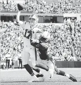  ?? TOM SZCZERBOWS­KI GETTY IMAGES ?? Josh Allen (17) of the Bills is hit as he throws by Melvin Ingram III of theLos Angeles Chargers duringNFL action at New Era Field in Buffalo on Sunday.