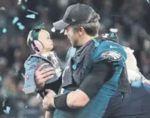  ?? Rob Carr, The Associated Press ?? Super Bowl MVP Nick Foles of the Eagles shares his celebratio­n with his daughter, Lily, on Sunday after Philadelph­ia’s 41-33 victory over the New England Patriots.