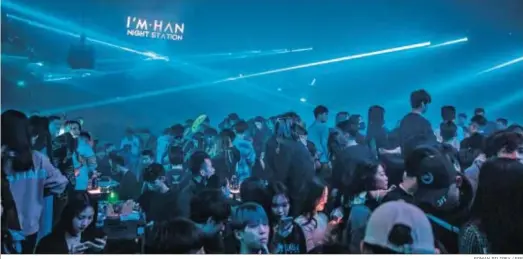  ?? ROMAN PILIPEY / EFE ?? Una multitud de jóvenes bailan la noche de fin de año en una de las principale­s discotecas de Wuhan.