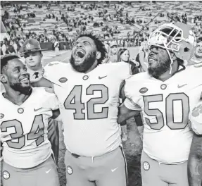  ??  ?? Clemson players celebrate their victory over South Carolina on Saturday. JIM DEDMON/USA TODAY SPORTS