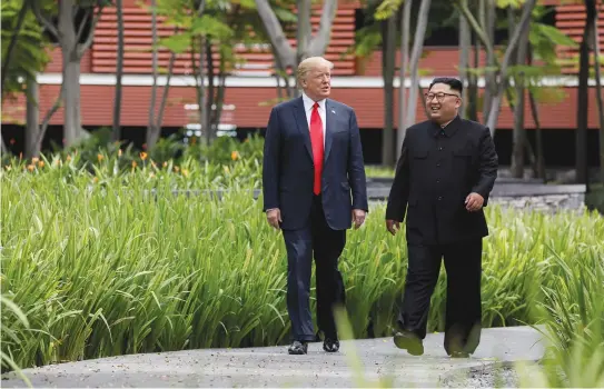  ?? (Jonathan Ernst/Reuters) ?? US PRESIDENT Donald Trump and North Korea’s leader Kim Jong Un walk together in Sentosa, Singapore on Tuesday.