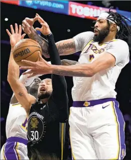  ?? Jae C. Hong Associated Press ?? LAKERS FORWARD Anthony Davis, right, battles for a rebound with Warriors guard Stephen Curry. Davis finished with 39 points and eight rebounds in the win.