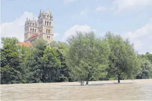  ?? FOTO: WAGNER/IMAGO IMAGES ?? Ein Sommertag in München nach Regentagen: Hier die Isar in München mit hohem Pegelstand, wo normal eine kleine Insel ist, versanken die Bäume im Wasser.