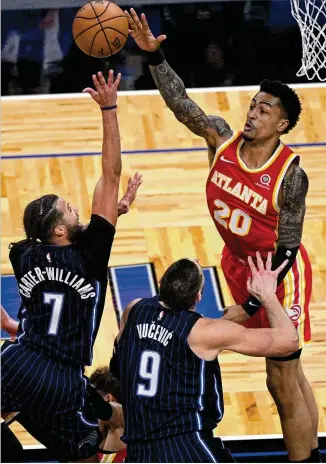  ?? PHELAN M. EBENHACK/ASSOCIATED PRESS ?? Hawks power forward John Collins, looking to block a shot from Magic guard Michael Carter-williams on Wednesday, is averaging 18 points, 7.6 rebounds and shooting 39% from 3-point range. He has started and played in all 36 games during the first half.