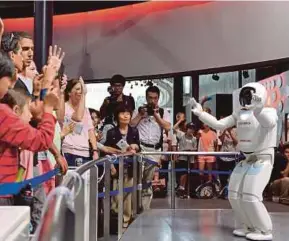  ?? AFP PIC ?? Honda Motor's humanoid robot Asimo interactin­g with visitors at the National Museum of Emerging Science and Innovation in Tokyo in 2013.