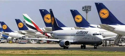  ?? Foto: AP Content ?? Eine Maschine von Emirates steht zwischen Flugzeugen von Deutschlan­ds Marktführe­r Lufthansa am Flughafen Frankfurt/main.