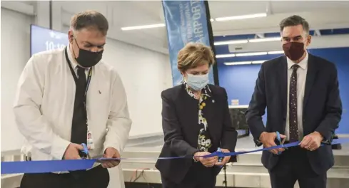  ?? Bill Atwood ?? Airport manager Chris Wood, regional Chair Karen Redman and Kitchener-Conestoga MP Tim Louis cut the ribbon Apr. 21 to officially open the expanded terminal at the Breslau facility.