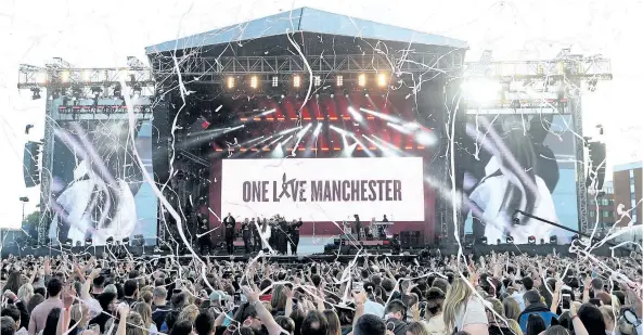  ?? DAVE HOGAN/THE ASSOCIATED PRESS ?? Ariana Grande, onstage in white, performs at the One Love Manchester tribute concert in Manchester, north western England, on Sunday. One Love Manchester is raising money for those affected by the bombing at the end of Ariana Grande’s concert in...