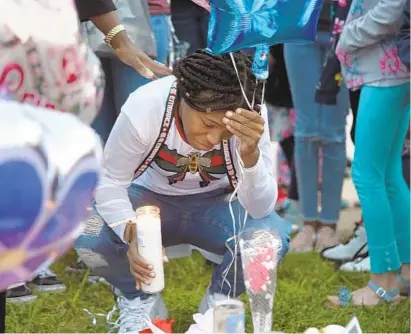  ?? BARBARA HADDOCK TAYLOR/BALTIMORE SUN ?? Brittany Morgan gets emotional Friday as she places a candle at a makeshift memorial for her daughter, Na Tasha Newman. The 7year-old girl was struck by a vehicle and killed Thursday afternoon across the street from Sandalwood Elementary School in Essex.