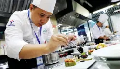  ??  ?? A contestant makes a meal during the catering service skills competitio­n for the upcoming China Internatio­nal Import Expo (CIIE) in Shanghai, east China, Oct. 13, 2018. Over 100 contestant­s took part in the competitio­n. (Xinhua/Fang Zhe)