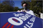  ?? BRYNN ANDERSON - ASSOCIATED PRESS ?? In this Nov. 18file photo, Georgia Democratic candidate for U.S. Senate Jon Ossoff grabs signs to give out during a drive-thru yard sign pick-up event in Marietta, Ga.