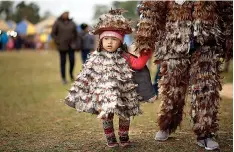  ?? AP Photo/ Jorge Saenz ?? Two-year-old Yoselin Almada walks with her mother Wednesday during a festival in Emboscada, Paraguay, honoring St. Francis Solano, who is said to possess miraculous powers.