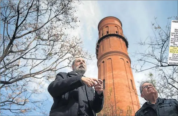  ??  ?? Jordi Fossas y Lluís Civit, el presidente y un directivo del Arxiu Històric del Poblenou, junto a la torre, en la plaza Ramon Calsina