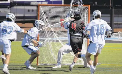  ?? KARL MERTON FERRON ?? Rutgers attacker Kieran Mullins (4) shoots between Johns Hopkins defender Jared Reinson (87), long-stick midfielder Hunter Jaronski (left of goal) and short-stick Alexander Mabbett to score on goalie Josh Kirson on Saturday.