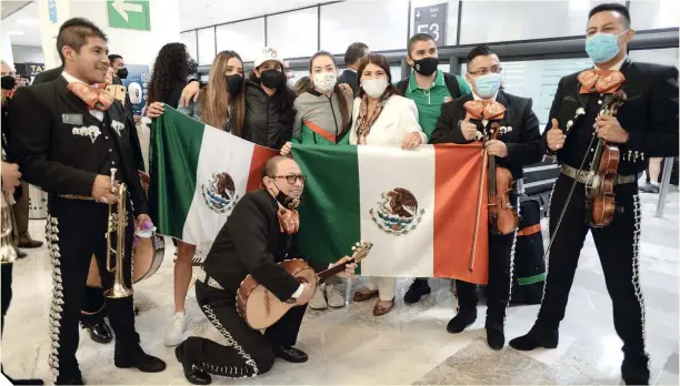  ??  ?? La ciclista Daniela Gaxiola, junto a su familia y el mariachi que ya la esperaban en la Terminal 1 del AICM, a su llegada de la capital japonesa.