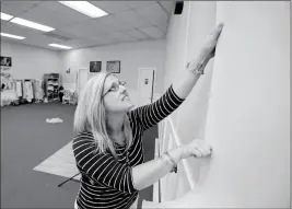  ?? ASSOCIATED PRESS ?? IN THIS PHOTO TAKEN July 10, Cathy Cooper adjusts a photo background at her studio in Ocala, Fla. Cooper, a cancer survivor, is concerned that if the GOP health bill goes through, she may not have access to the kind of health insurance she needs to...