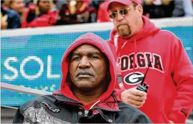  ?? PHOTOS BY CURTIS COMPTON / CCOMPTON@AJC.COM ?? Former heavyweigh­t champion Evander Holyfield, watching his son, Elijah Holyfield, believes that lessons from his upset knockout of Mike Tyson can be used to defeat Alabama on Saturday.