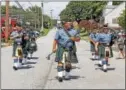  ??  ?? The Emerald Society bagpipers open the ceremony with music as they march in.