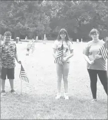  ?? Submitted Photo ?? Members of the Faith Weavers Youth Group of the First United Methodist Church in Wheatley helped the Wheatley community remember Memorial Day by placing flags on the graves of veterans who served their country honorably. From left, Trager Medford, Kaitlyn Pierce and Abby Taylor, members of the Faith Weavers under the direction of Betty McLain, pause for a photo while placing flags at Johnson Cemetery.