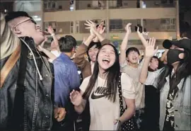  ?? Kin Cheung Associated Press ?? DEMOCRACY supporters celebrate early Monday after pro-Beijing politician Junius Ho conceded in Hong Kong, sparking scenes of joy on the streets.