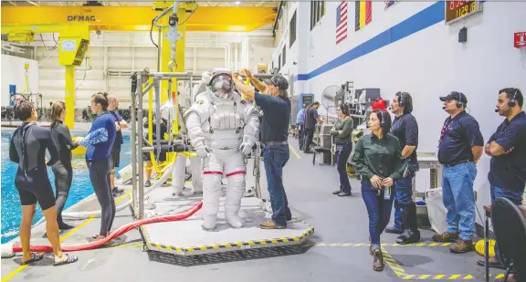  ??  ?? NASA astronaut Sunita Williams prepares to be lowered into a pool to practice for space missions.
JONATHAN NEWTON/FOR THE WASHINGTON POST