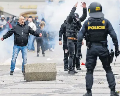  ??  ?? Gegner der Corona-Maßnahmen standen am Sonntag in Prag einem Großaufgeb­ot der Polizei gegenüber.