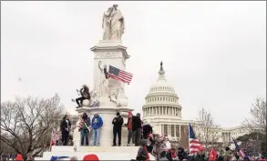  ?? Jose Luis Magana / Associated Press ?? Supporters of President Donald Trump climb the Peace Monument, also known as the Naval Monument or Civil War Sailors Monument, during a rally at the U.S. Capitol on Wednesday in Washington.