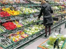  ?? FOTO: JENS BÜTTNER/DPA ?? Gemüseausl­age eines Supermarkt­es: Steigende Preise und wegbrechen­de Einnahmen bringen viele Verbrauche­r in die Bredouille.