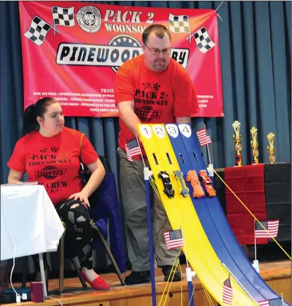  ?? Ernest A. Brown photos ?? Above, Micayla Ivins, Cub Master, left, watches as Pack Committee Chairman Adam Walsh sets off a pack of cars in the first heat of derby raising on Saturday. Below, Jase Barrett, 6, and Dalton Key, 8, watch as their cars are next up to race.