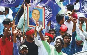  ?? AFP ?? ■ Protesters carry a portrait of social reformer B.R. Ambedkar during a countrywid­e strike against a Supreme Court order in Allahabad yesterday.