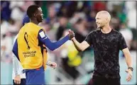  ?? Ashley Landis / Associated Press ?? United States’ Tim Weah, left, and head coach Gregg Berhalter celebrate after defeating Iran in the World Cup group B soccer match Tuesday at the Al Thumama Stadium in Doha, Qatar.