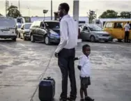  ??  ?? Left: Drivers buy food while waiting in line for fuel — a wait that can last hours. Right: Some gas stations in Lagos are refusing to sell gas to people with plastic gas cans, fearing the gas could end up on the black market.