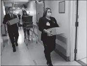 ?? DANA JENSEN THE DAY ?? Lawrence + Memorial Hospital staff carry boxes of COVID-19 vaccines in the hospital in 2020.