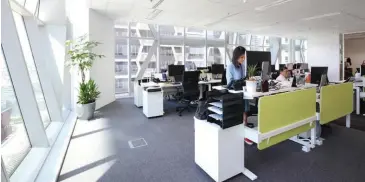  ?? SAMUEL ISAAC CHUA/ EDGEPROP SINGAPORE ?? The Edmund Tie office has adjustable desks for those who prefer standing while they work