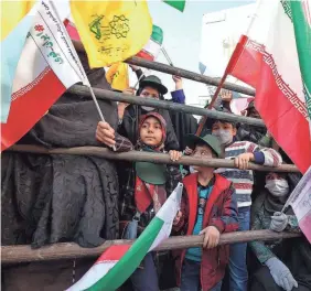  ?? ATTA KENARE/AFP VIA GETTY IMAGES ?? Iranians carry their country's flags during a rally outside the former US embassy in Tehran on Nov. 4, 2022, to mark the 43rd anniversar­y of the start of the Iran hostage crisis.