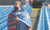  ?? John Leyba, The Denver Post ?? A Broncos fan drapes himself in a team flag before the Bills game Sunday.
